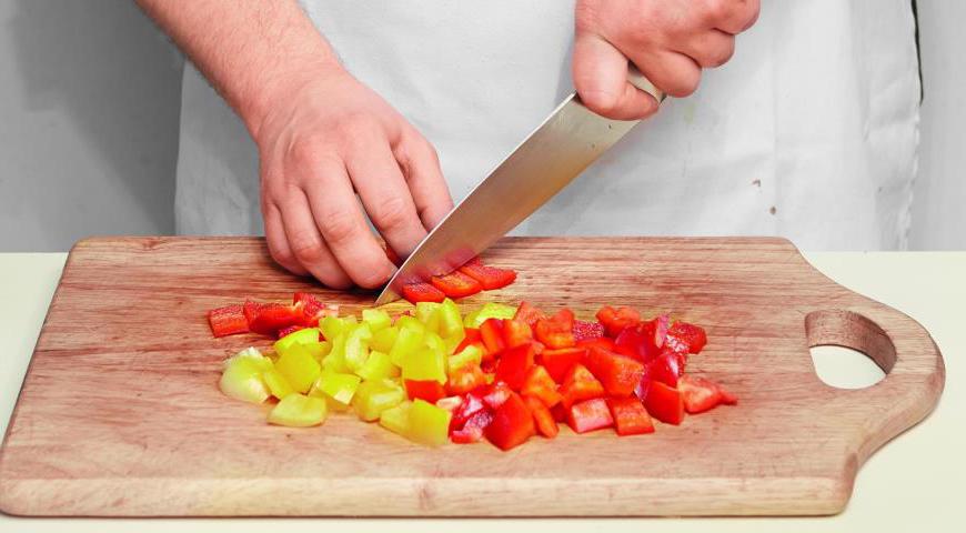 Красный и желтый перец разрежьте пополам, удалите семена и перегородки, а затем нарежьте аккуратными кубиками размером около 1 см.