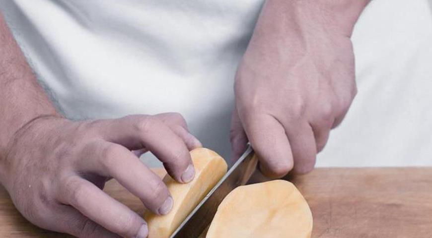 Очистите картофель, разрежьте каждую картофелину вдоль пополам, положите в широкую кастрюлю, залейте холодной водой так, чтобы картофель был закрыт не полностью. На сильном огне доведите до кипения, посолите, закройте крышкой и уменьшите огонь до слабого. Варите до совершенной мягкости картофеля, примерно 35 минут.