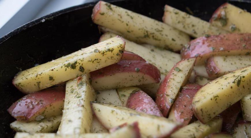 Картофель тщательно вымойте, обсушите, нарежьте дольками, слегка посолите, посыпьте любимыми специями и сбрызните растительным маслом. Запекайте отдельно в духовке при температуре 190°C в течение 20 минут до золотистой корочки.