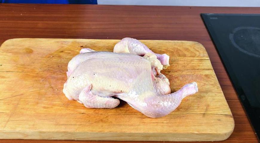 Тщательно посолите и поперчите курицу внутри и снаружи. Внутрь положите 4 веточки тимьяна и 3 зубчика чеснока. Снаружи аккуратно нанесите оливковое масло, чтобы курица не высохла во время запекания.