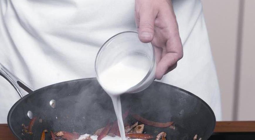 Влейте кокосовое молоко, добавьте соль и сахар по вкусу. Прогрейте смесь до кипения, затем добавьте лапшу и доведите её до готовности. За 2-3 минуты до окончания приготовления введите горошек. Перед подачей полейте блюдо соком лайма и украсьте листочками кинзы.