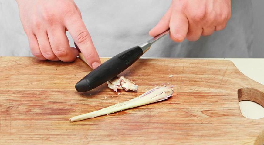 Разомните стебли лемонграсса с помощью ножа или молотка. Нижнюю часть одного стебля нарежьте как можно мельче и отправьте в ступку. Остальной лемонграсс нарежьте крупными кусками.