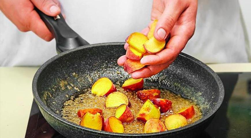 Нарежьте персики дольками, исключив косточку. В сковороде расплавьте масло с сахаром, добавьте фрукты и прогрейте, аккуратно перевернув их один раз.