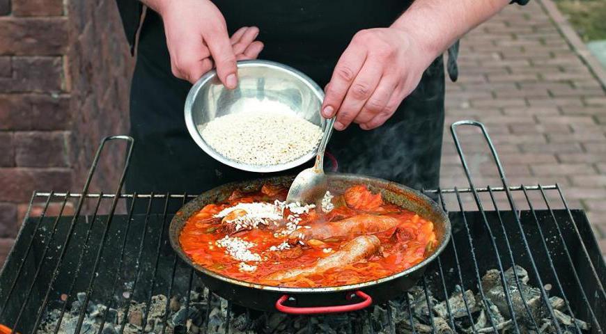 Осторожно всыпьте рис между кусками мяса, полностью погружая его в бульон (при необходимости помогите деревянной лопаткой). Не перемешивайте! Посолите и поперчите по вкусу. Готовьте до тех пор, пока рис не впитает всю жидкость. После этого снимите сковороду с огня и дайте паэлье настояться перед подачей.