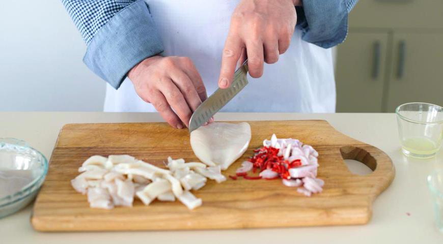 Используя очень острый нож, сделайте надрезы крест-накрест на внешней стороне филе кальмара, но не прорезая его полностью. Нарежьте кальмара на полоски размером примерно 3х2 см.