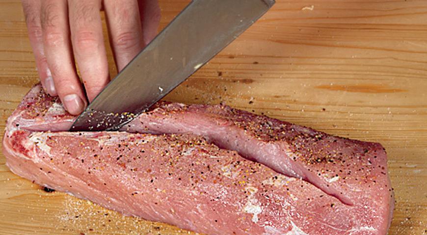 Аккуратно перевернуть мясо ненашпигованной стороной кверху. Сделать по продольной оси куска прямой надрез глубиной около 1,4 см, не доходя до краев по 4–5 см. Затем, погрузив нож в разрез, сделать внутри куска симметричные надрезы под углом 45° с обеих сторон на глубину около 4,2 см. Это нужно для того, чтобы в кусок мяса поместилось больше фарша.