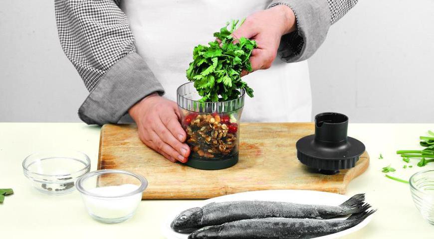 Измельчите грецкие орехи, чеснок, кинзу и нарезанный стручковый перец чили в ступке с добавлением щепотки соли или используйте мясорубку. Введите белый винный уксус и тщательно перемешайте ингредиенты до получения однородной пасты. Намажьте полученной смесью каждую рыбину как внутри, так и снаружи.
