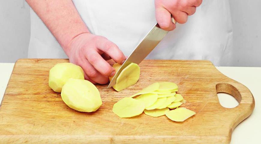 Очистите картофель и нарежьте его тонкими кружочками (толщиной не более 2 мм), используя терку или острый нож. Лук очистите и нарежьте тонкими полукольцами, аналогично по толщине картофелю.