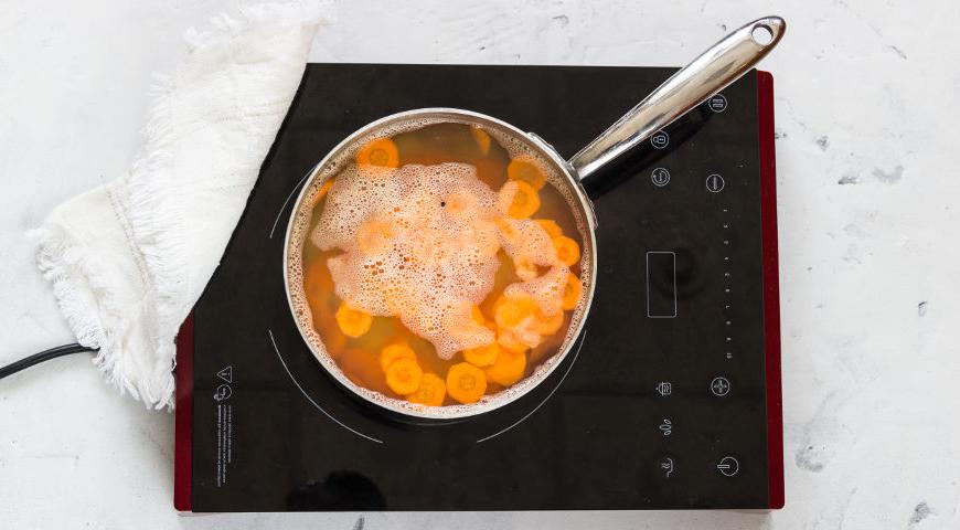 Очистите картофель, морковь, помидоры и лук, нарежьте кружками толщиной около 6–7 мм. Отложите несколько веточек зелени для украшения, остальные мелко порубите. Положите картофель в подсоленную кипящую воду на 3 минуты, добавьте морковь и проварите еще 2 минуты. Аккуратно слейте воду.