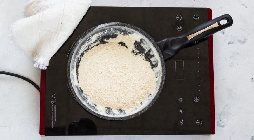 Обжарьте муку на сухой сковороде до золотистого цвета в течение 1 минуты. Натрите сыр на крупной терке. Всыпьте муку в сметану, добавьте две трети тертого сыра. Посолите и поперчите по вкусу. Тщательно перемешайте и равномерно распределите смесь по поверхности запеканки.