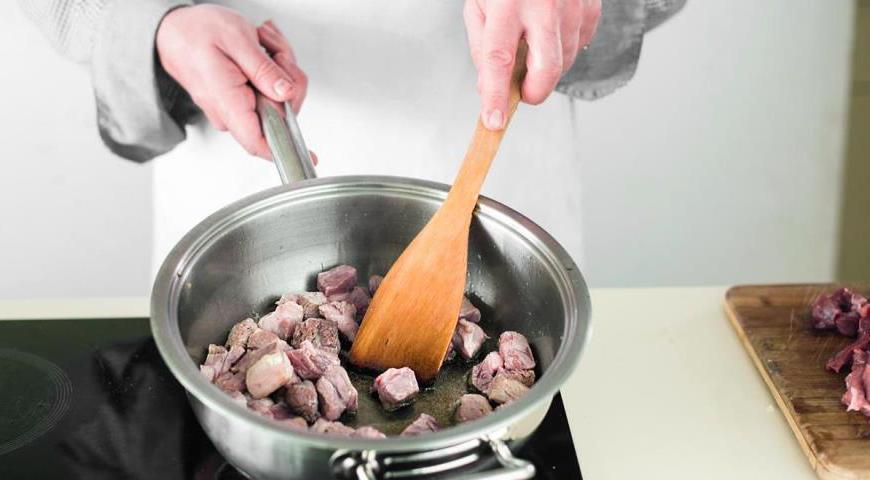 Добавьте часть мяса в расплавленное сало так, чтобы кусочки не соприкасались. Увеличьте огонь и обжарьте мясо до румяной корочки со всех сторон. Переложите его шумовкой на тарелку и повторите процедуру с остальным мясом.