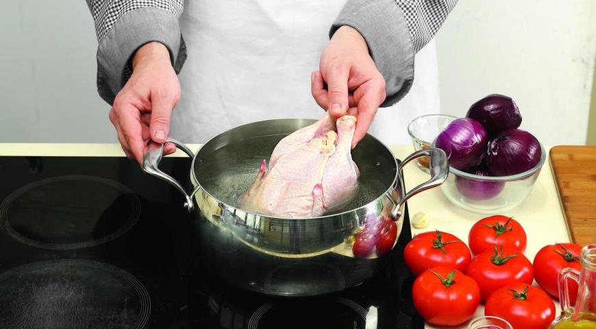 Положите курицу в кастрюлю с 2,2 л кипящей воды, варите до полуготовности около 35 минут. Достаньте курицу, дайте ей остыть примерно 20 минут. Разрежьте на порционные куски вместе с костями и процедите бульон.
