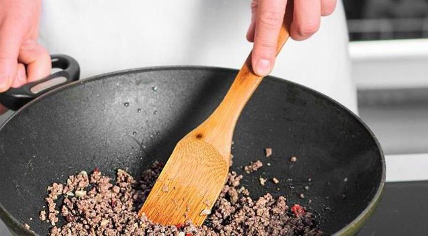 Добавьте фарш в сковороду, разбивая комки деревянной лопаткой. Жарьте до тех пор, пока мясо не изменит цвет и не станет золотистым.