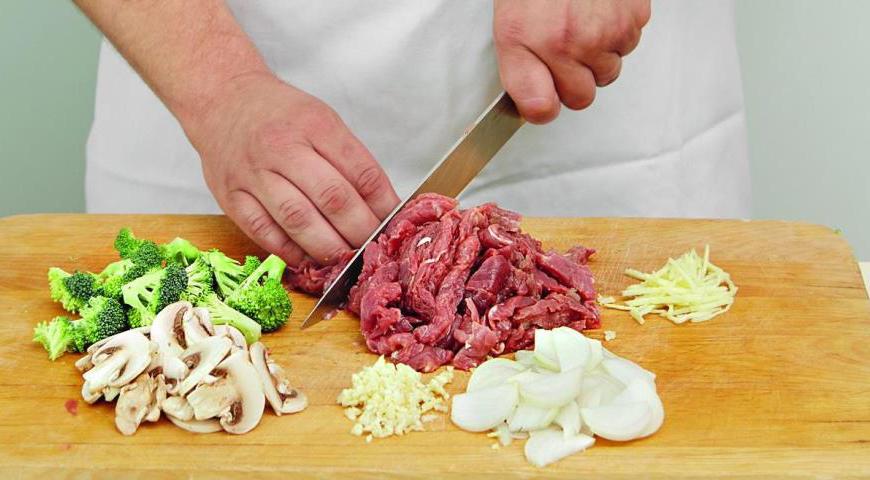 Начните с подготовки всех продуктов: очистите и порежьте брокколи на соцветия, лук — на тонкие полоски, чеснок и имбирь измельчите. Шампиньоны нарежьте пластинками, а говядину — тонкими ломтиками. Это обеспечит равномерное приготовление и лучшее распределение вкуса.