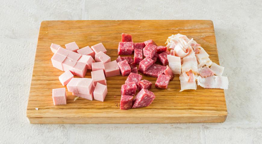 Все имеющиеся мясные продукты порежьте небольшими частями для равномерной пропитки вкусом.