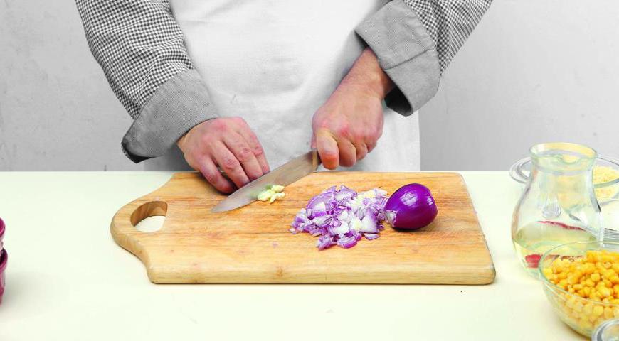 Очистите красные луковицы и чеснок, мелко нарежьте их. Также разрежьте чили пополам, уберите семена и перегородки, а мякоть нарежьте тонкими полукольцами.