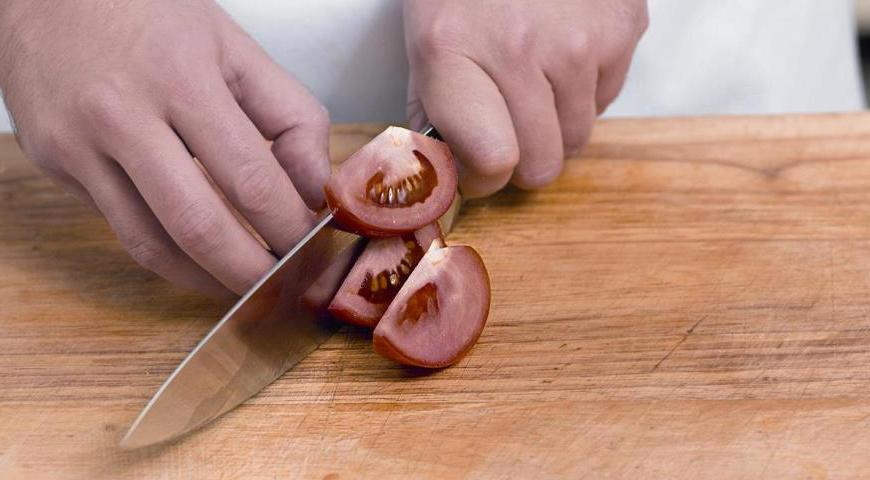 Добавьте помидоры и часть чеснока в сковороду, посолите и поперчите по вкусу. Накройте крышкой, дайте закипеть. Снимите с огня, добавьте остальной чеснок и зелень, хорошо перемешайте и подавайте горячим.