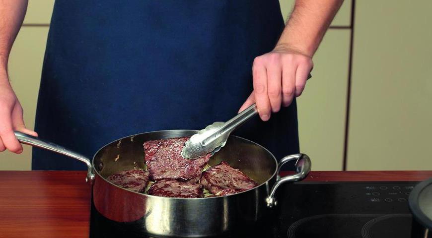 Верните в сотейник чеснок и мясо, влейте столько кипятка, чтобы мясо оказалось полностью покрыто им. Доведите до кипения и тушите под крышкой 65 минут.