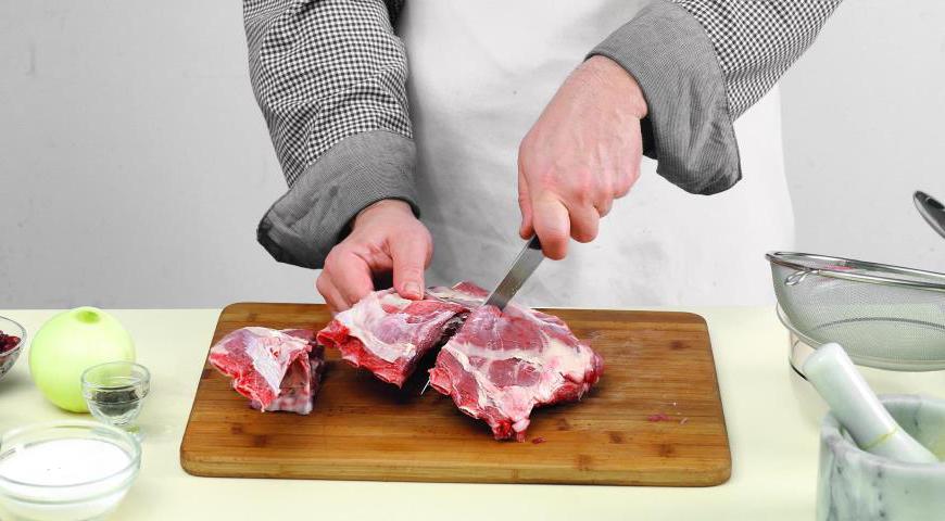 Нарежьте баранью тушку на порционные куски, аккуратно разделяя соединительную ткань между ребрами, чтобы мясо оставалось целым и сочным.