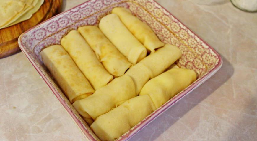 Подготовленные блины с начинкой аккуратно укладываем в форму для запекания, стараясь не повредить их форму. Можно использовать форму любого удобного размера, желательно покрытую пергаментом или слегка смазанную маслом.
