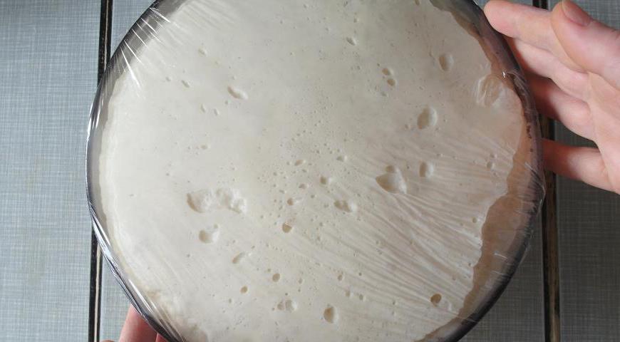 Когда тесто подойдёт, включите духовку на 180°C, если она ещё не была включена. Подготовьте противень, застелив его антипригарным пергаментом. Также подготовьте семечки и емкость с водой для смазывания заготовок.