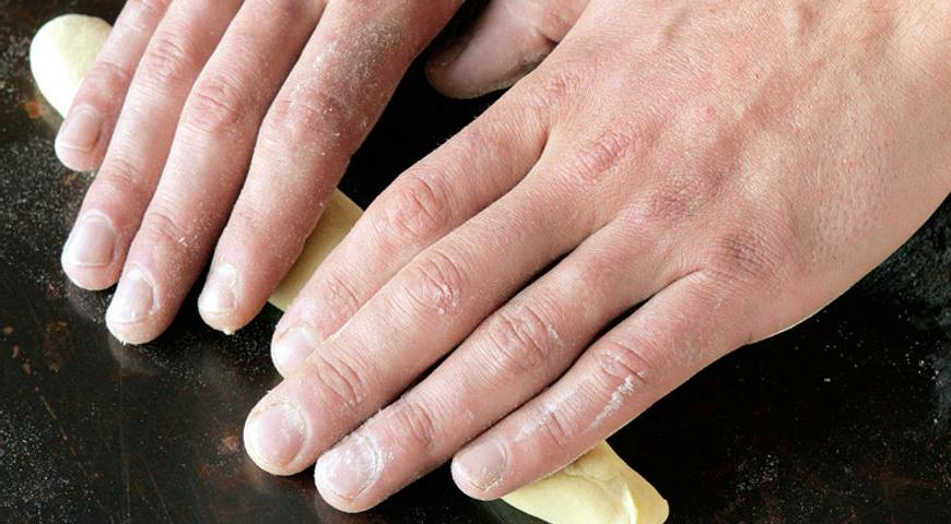 Присыпьте рабочую поверхность мукой. Скатайте каждую часть теста в длинные колбаски около 27 см, следя за равномерностью толщины и отсутствием пузырьков воздуха.