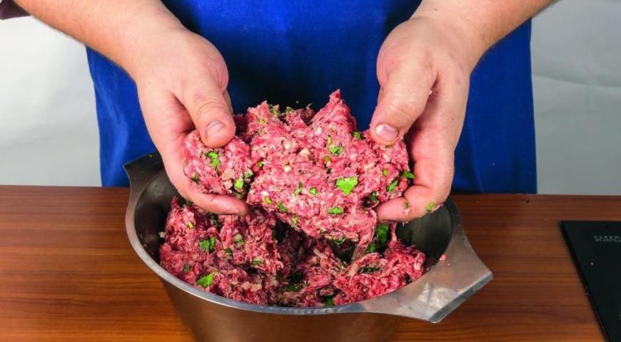 Подготовьте мясо, нарезав его на небольшие кусочки и пропустив через мясорубку дважды с мелкой решеткой. Очистите лук и измельчите его. Добавьте кинзу, постепенно вводя соль и смесь специй, затем тщательно вымесите фарш до однородной массы.