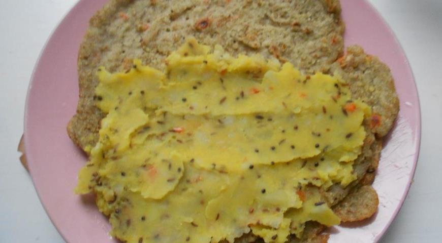 На каждую половину блина положите немного картофельной начинки, затем аккуратно сверните их пополам.