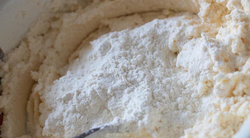Всыпьте просеянную муку и сахар по вкусу. Перемешайте тесто до такого состояния, чтобы оно легко отставало от рук.