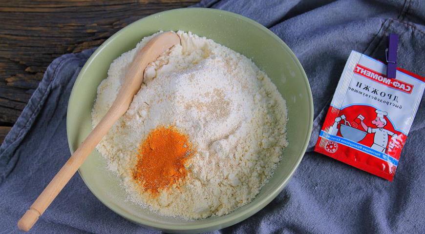 Просейте пшеничную и кукурузную муку, добавьте соль, куркуму и дрожжи. Хорошо перемешайте, чтобы все компоненты равномерно распределились. Куркума придаст тесту красивый золотистый цвет и слегка пряный аромат, но её можно опустить при желании.