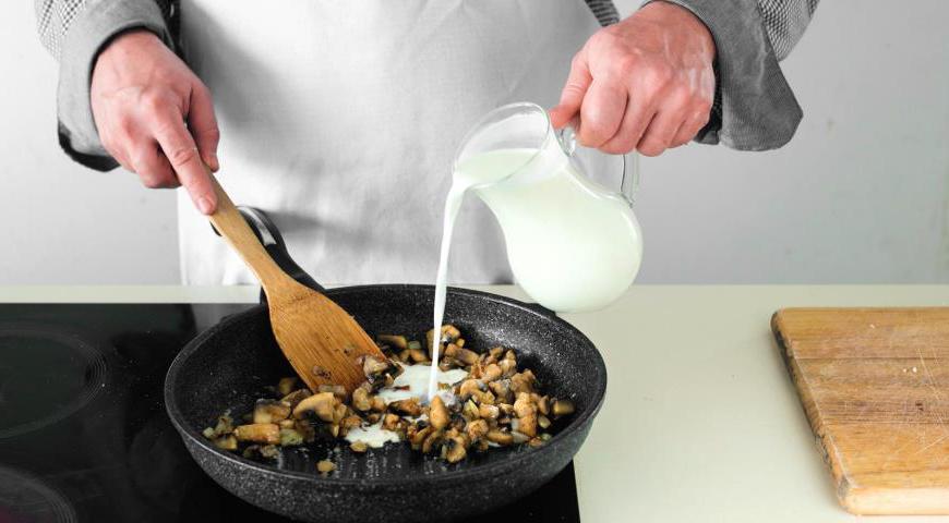 Посыпьте содержимое сковородки мукой, перемешайте и потушите несколько минут. Постепенно влейте молоко, постоянно помешивая, чтобы избежать комков. Готовьте соус до загустения, регулируя густоту по своему вкусу.