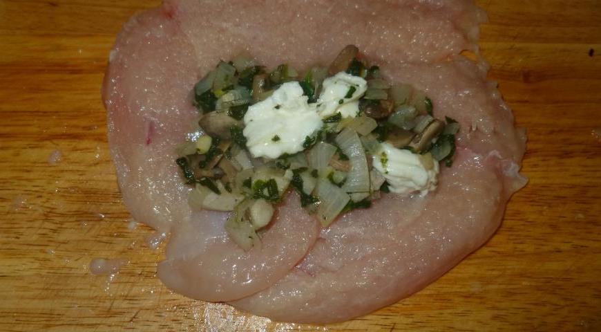 Выложите на каждый кусок курицы по 2 столовые ложки начинки с горкой.