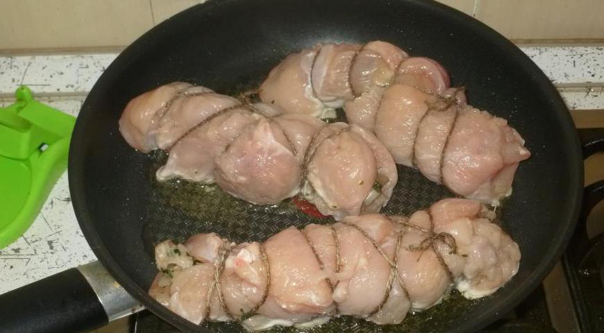 Обжарьте рулеты на сковороде до золотистой корочки, затем переложите в форму и запекайте в духовке при 190°C около 30 минут.