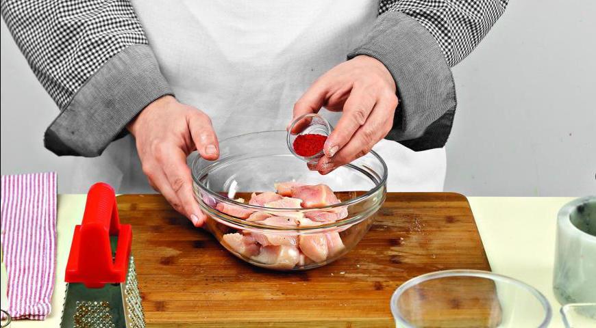 Нарежьте куриное филе кубиками размером примерно 3,5 см. Приправьте их солью и молотой паприкой.