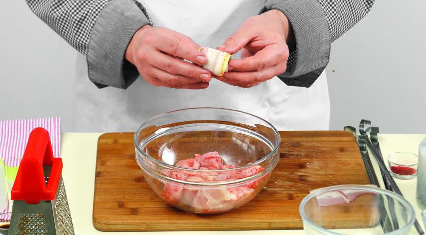 Оберните каждый кусочек куриного филе сначала листом лука-порея, а затем полоской сала.