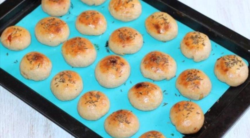 После этого выньте пирожки из духовки, увеличьте температуру до 200°C. Смажьте их взбитым яйцом с молоком, посыпьте тмином и отправьте обратно в духовку еще на 5 минут. Выполняйте этот шаг быстро, чтобы изделия не остыли.