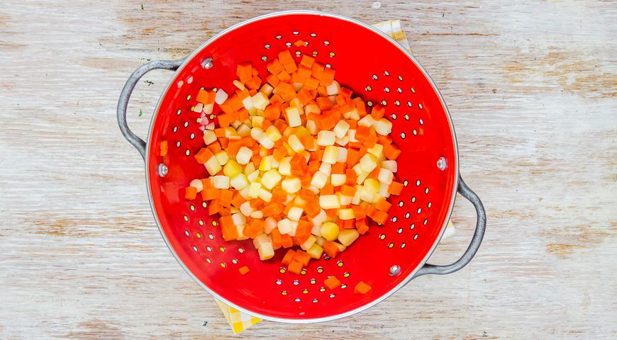 Нарежьте картофель и морковь на мелкие кубики. Отварите их в подсоленной воде до мягкости. Замочите горошек в кипятке на 5 минут, затем слейте воду и дайте ему обсохнуть.