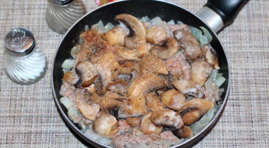 Промойте и очистите шампиньоны, нарежьте их дольками и добавьте к фаршу. Продолжайте обжаривать на среднем огне.