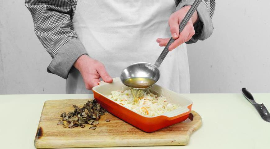 Разогрейте духовку до 145 °C. Квашеную капусту слегка промойте, отожмите лишнюю жидкость, нарежьте кусочками длиной около 2 см и поместите в глубокую керамическую форму. Залейте немного грибного настоя и отправьте в духовку на 1 час.