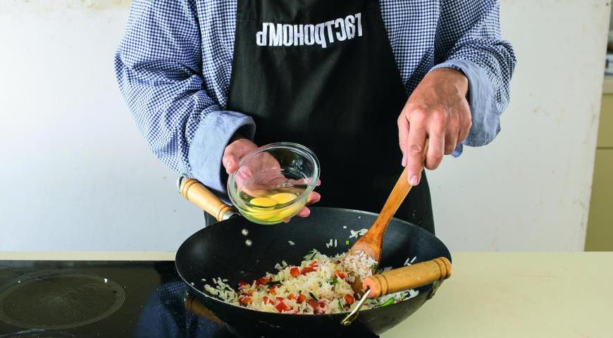 Добавьте охлажденный рис в сковороду и прогрейте его. Разбейте два яйца прямо в рис и, постоянно помешивая, жарьте на сильном огне до тех пор, пока яйца не будут полностью готовы. Посолите, поперчите по вкусу, затем разложите по тарелкам. Украсьте готовыми ребрышками и подайте с соевым соусом.