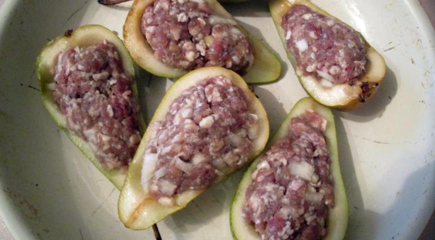 Наполните подготовленные половинки груш мясной начинкой. Уложите их в форму для запекания и отправьте в духовку на 20 минут.