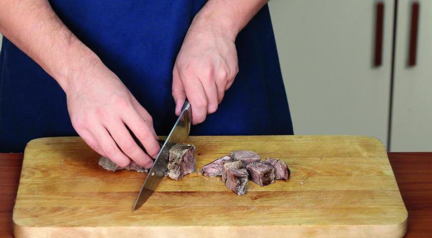 Достаньте грудинку из бульона, аккуратно срежьте мясо с костей небольшими кусочками и верните его обратно в бульон (кости можно выбросить).