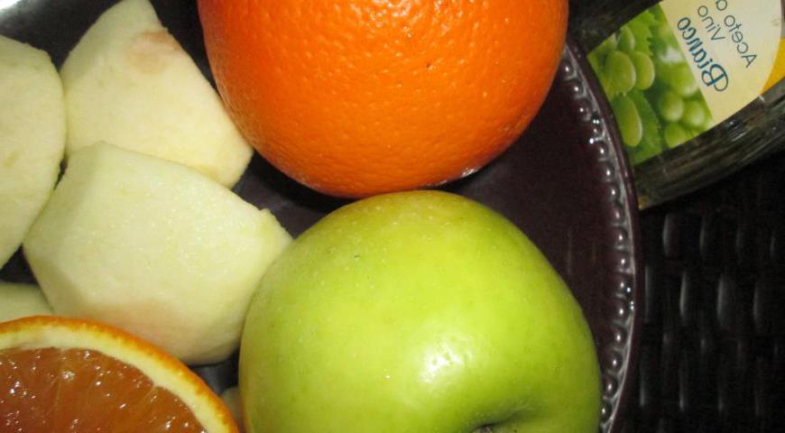 Нарежьте очищенные яблоки и апельсины дольками. Сбрызните их яблочным уксусом, добавьте изюм и протушите на среднем огне в течение 15 минут до мягкости.