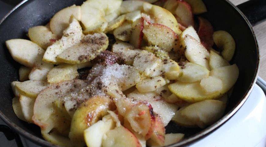 На сковороде растопите сливочное масло, выложите яблоки и обжаривайте на среднем огне до мягкости. Добавьте 4 чайные ложки сахара и щепотку корицы, перемешайте и снимите с огня. Оставьте яблоки остывать.
