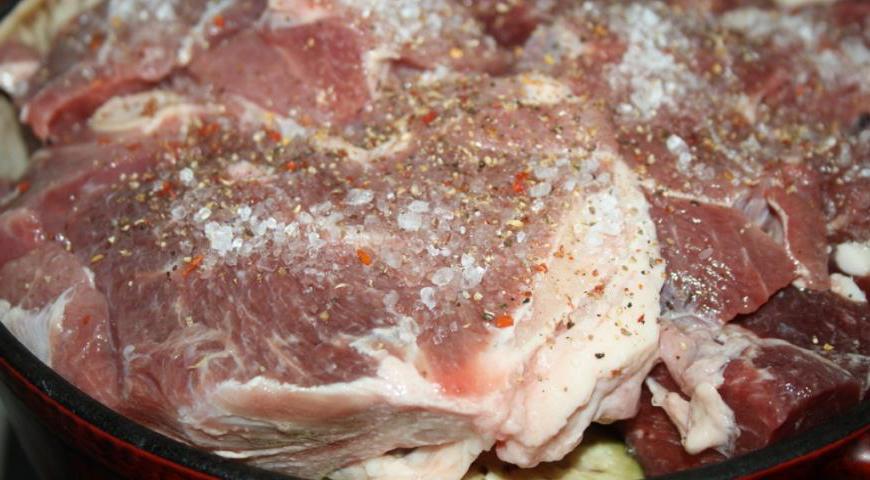Баранину нарежьте крупными порционными кусками, выложите сверху на овощи. Добавьте соль и перец по вкусу.