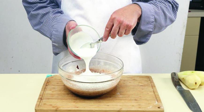 В отдельной миске взбейте яйца с сахаром до увеличения в объеме. Введите растопленный шоколад, йогурт и мучную смесь, аккуратно перемешайте до однородности.