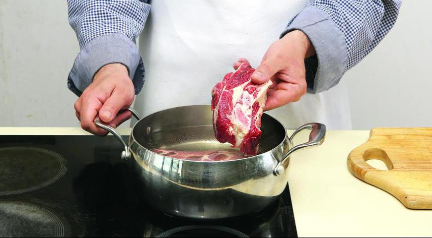Полностью разморозьте тесто заранее. Положите мясо в кастрюлю, залейте кипящей водой полностью, доведите до кипения, посолите, снимите пену. Добавьте половину луковицы и морковку, варите до мягкости мяса около 1,7 часа. Выньте мясо из бульона и мелко порубите вместе с жирком.