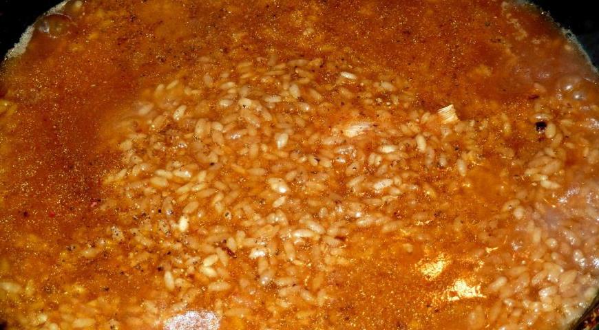 Очистите чеснок от верхней кожуры, промойте и положите прямо в казан. Аккуратно выложите промытый рис поверх мяса, равномерно распределив его по поверхности. Залейте кипятком так, чтобы уровень жидкости был примерно на два пальца выше риса. Посолите и добавьте специи по вкусу.