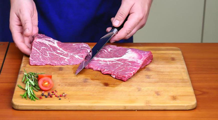 Продолжайте разрезать мясо, отслаивая верхнюю часть, чтобы контролировать процесс. Тщательно удалите соединительную ткань и разделите мясо на порционные куски размером примерно 150-200 грамм.