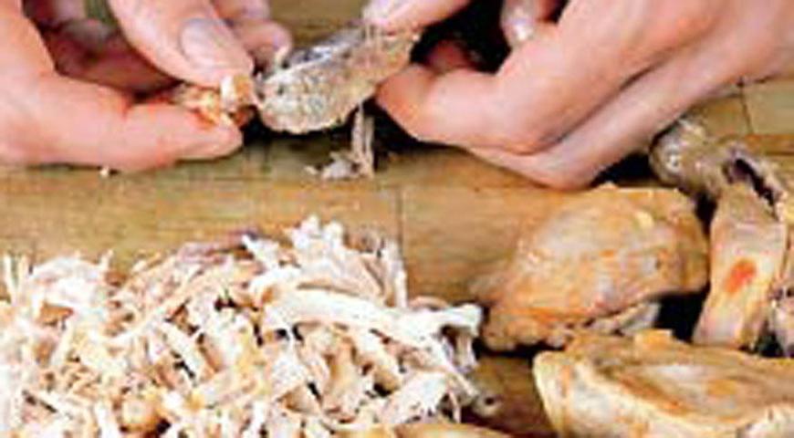Выловите куски цыпленка шумовкой, дайте немного остыть, разделите мясо на волокна. Верните его в суп, добавьте еще 550 мл кипятка, всыпьте кускус и готовьте, постоянно помешивая. За 5 минут до конца добавьте рубленую зелень и фисташки. Готовьте открыто еще 20 минут.